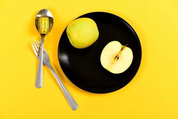 Succosa mela verde che giace sul piatto con cucchiaio e forchetta — Foto Stock