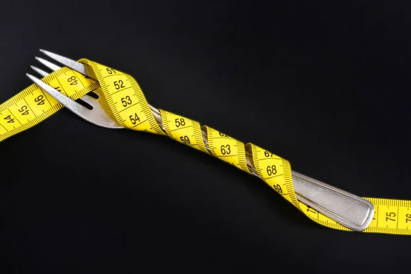 Bestick objektet svepte tätt med ljusa gula flexibel linjal — Stockfoto
