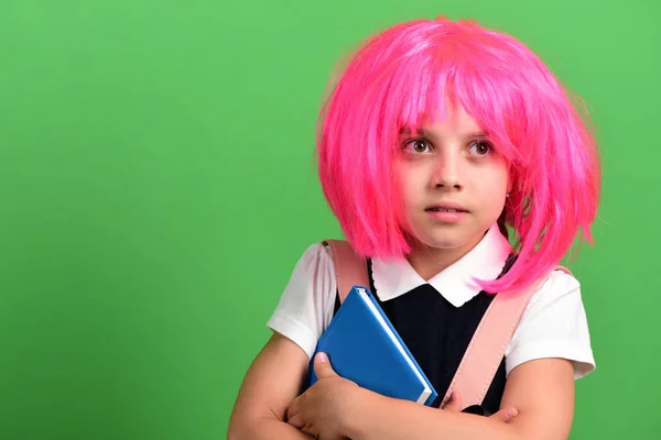 School girl in wig with surprised face on green background — Stock Photo, Image