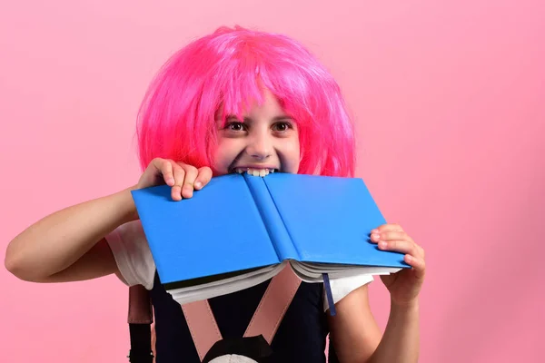 La chica muerde un gran libro azul. Regreso al concepto escolar — Foto de Stock