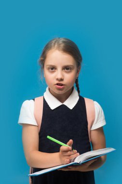 Okul üniformalı çocuk mavi arka planda izole edilmiş. Konsept çalış