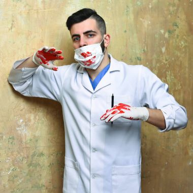 Bej arka planda laboratuvar önlüklü bir adam.