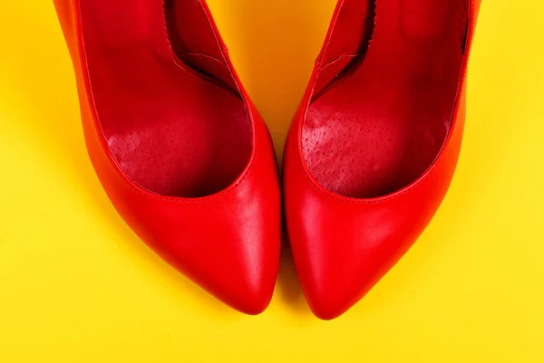 Κόκκινα ψηλοτάκουνα παπούτσια για ζουμερά κίτρινο φόντο — Φωτογραφία Αρχείου