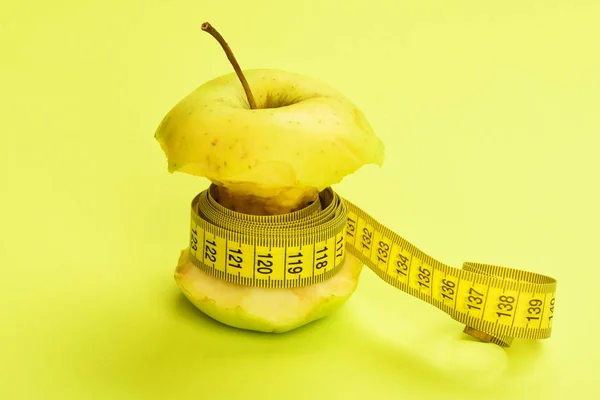 Kost koncept: bitten apple knuten runt med gult måttband — Stockfoto