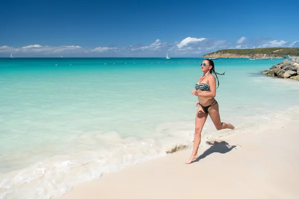 Женщина с сексуальным телом в бикини бегает по пляжу — стоковое фото
