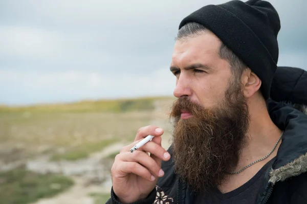 Man hipster eller kille med skägg och mustasch rökning cigarett — Stockfoto