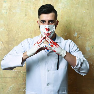 Elleri kanlı ve kendinden emin bir cerrah.