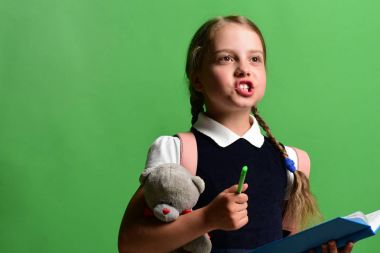 Okul üniformalı, örgülü ve pembe sırt çantalı bir öğrenci.