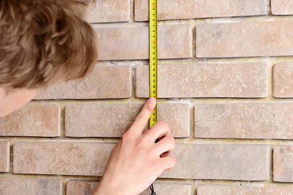 Bej tuğla arka planda rulet oynayan işçi, seçici odaklı