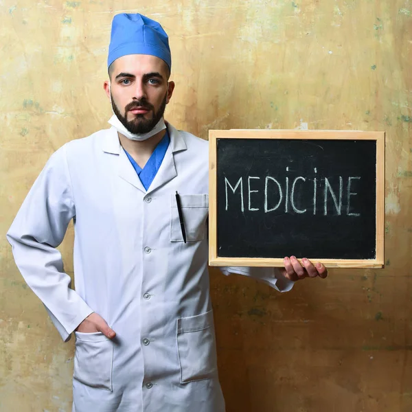 Medicina e ideia de recuperação. Doutor com barba segura pouco quadro negro — Fotografia de Stock