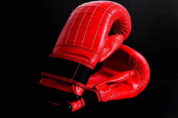 Black studio background with red mittens for boxing