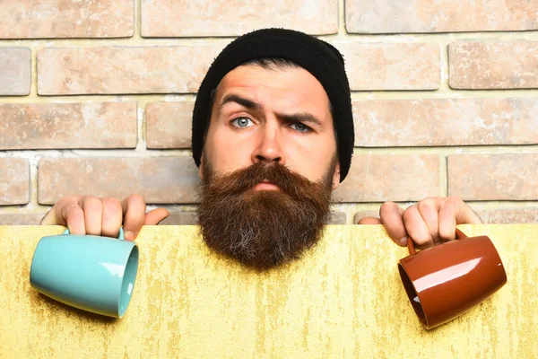 Barbudo brutal hipster caucásico con hoja de papel y tazas —  Fotos de Stock