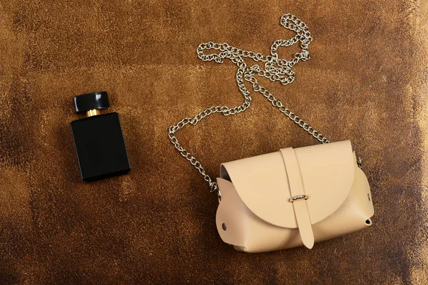 Bőr pénztárca és parfüm üveg barna velúr háttér — Stock Fotó