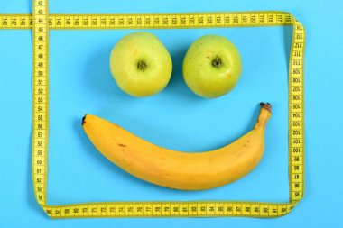 Muz ve yeşil elma cetvel ile çerçeveli gülümseme yapılmış