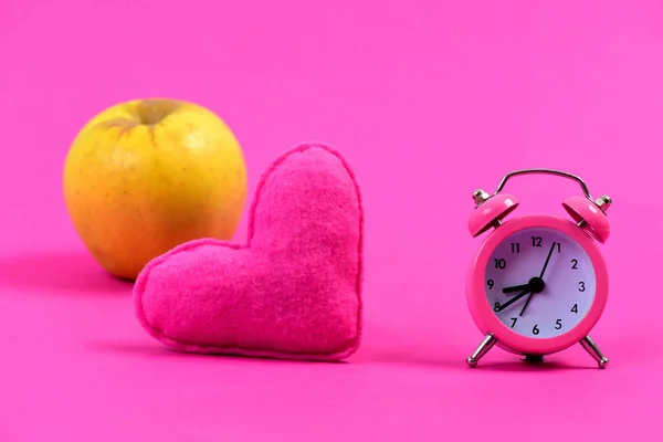 Heart near alarm clock and ripe apple — Stock Photo, Image