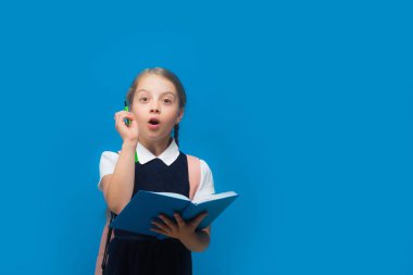 Kız örgü fikir sahip olmak. Öğrenci büyük mavi kitap tutar