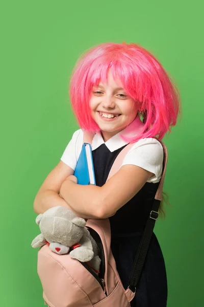 Childhood and back to school concept. Schoolgirl with pink wig — Stock Photo, Image