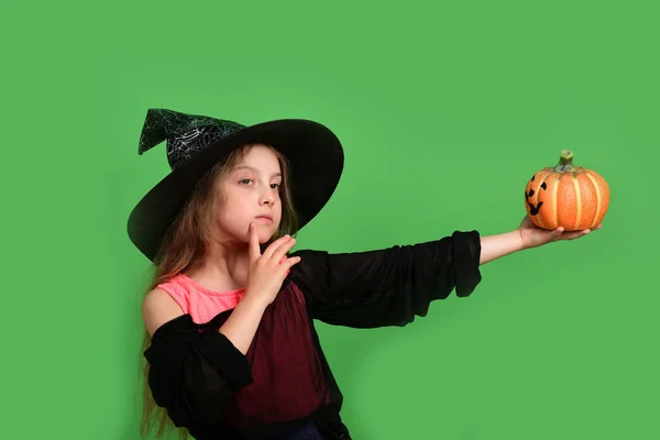 Lány faragott narancssárga tök elszigetelt zöld háttér — Stock Fotó