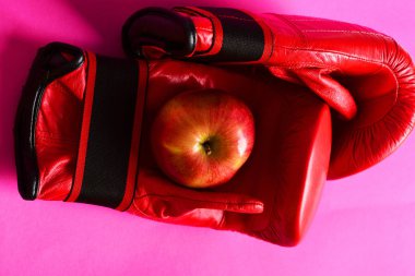 Spor donatımı ve kırmızı meyve arka plan pembe. Boks eldivenleri