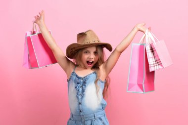 Kendine güvenen ve mutlu yüzlü çocuk kovboy şapkası takıyor.