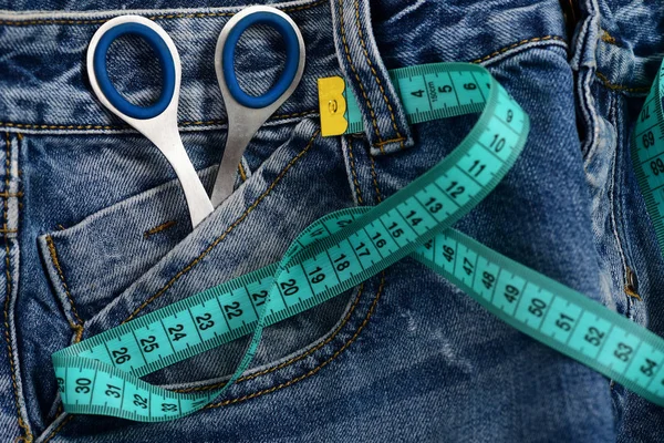 Metalen schaar in jeans zak met maatregel tape — Stockfoto