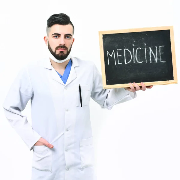 Lekarz z brodą trzyma małą tablicę ze słowem medycyna — Zdjęcie stockowe