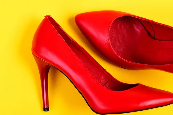 Elegantes zapatos femeninos en color rojo sobre jugoso fondo amarillo — Foto de Stock