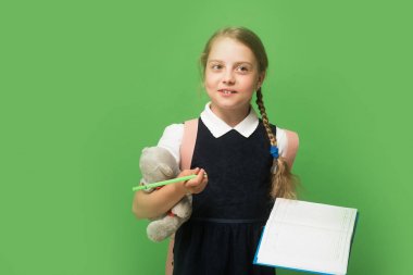 Kurnaz yüzlü, örgülü, yeşil elbiseli liseli kız.