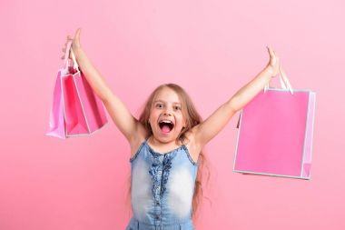 Paketleri pembe arka planda olan liseli kız.