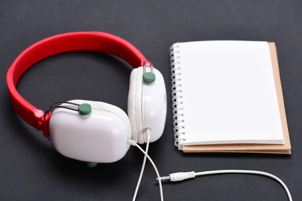 Modern and stylish earphones on dark background, close up