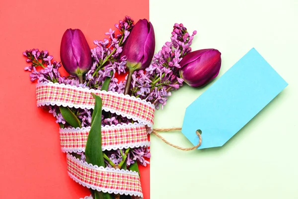 Tulipanes y flores lila con llamativa etiqueta de precio azul — Foto de Stock