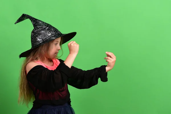 Kid in heks hoed, jurk en geconcentreerde gezicht — Stockfoto