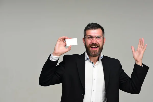 Sakallı takım elbiseli adam beyaz kartvizit tutar — Stok fotoğraf
