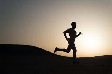 gün batımı, genç beyaz koşmak dağ içinde siluet koşan adam