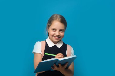 Öğrenci ile yeşil işareti mavi kitapta yazıyor. Çalışma kavramı