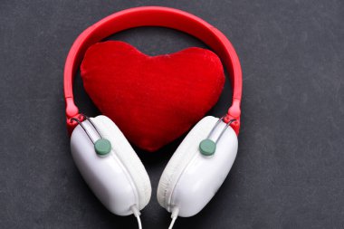 Beyaz ve kırmızı renkli yumuşak oyuncak kalp ile kulaklıklar