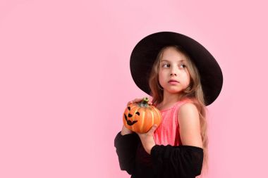 Cadı kostümü giymiş çocuk ve Jack O Lantern.