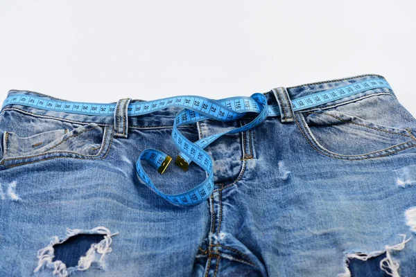 Fita métrica azul usada como cinto em jeans, close-up — Fotografia de Stock