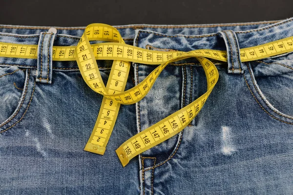 Sağlıklı yaşam tarzı ve diyet kavramı: kot pantolon ve ölçü birimi teyp — Stok fotoğraf
