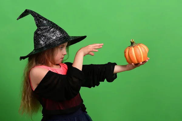 Meisje met gesneden oranje pompoen geïsoleerd op groene achtergrond — Stockfoto