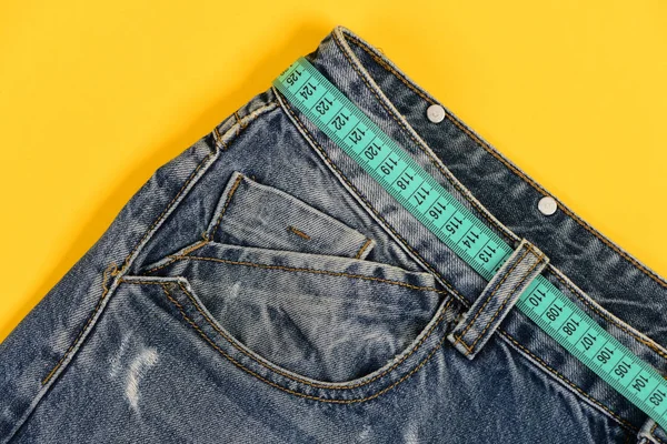 Top part of denim trousers isolated on yellow background — Stock Photo, Image