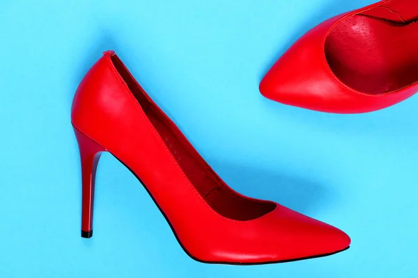 Причудливый высокий каблук красные туфли изолированы на синем фоне — стоковое фото