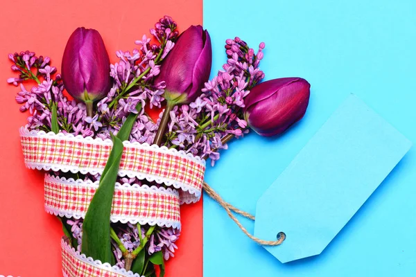 Manojo de tulipanes envuelto con cinta y etiqueta de nota azul brillante — Foto de Stock
