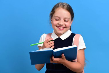 Okula ve eğitim konseptine geri dönmek. Kız mavi kitabı tutuyor.
