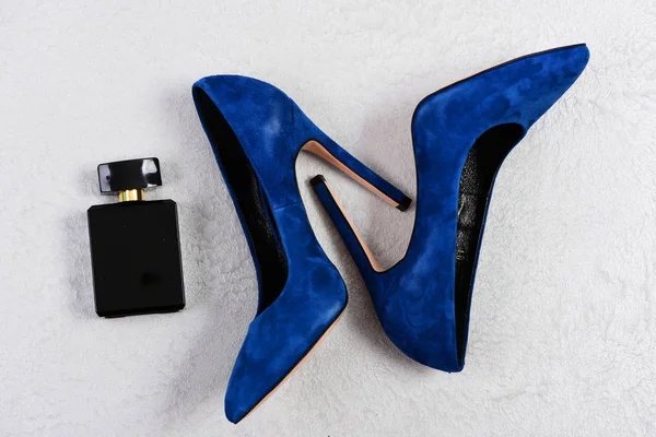 Женская обувь в темно-синем цвете и черный флакон духов — стоковое фото