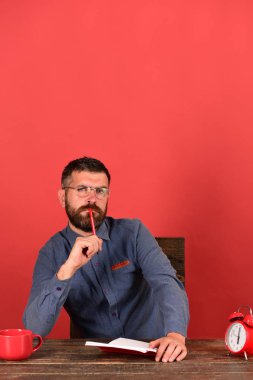 Kupası, retro saat ve vintage masada kırmızı kitap