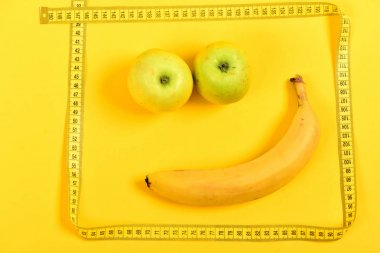 Olgun muz ve sulu elma gülümseme ile karşı karşıya