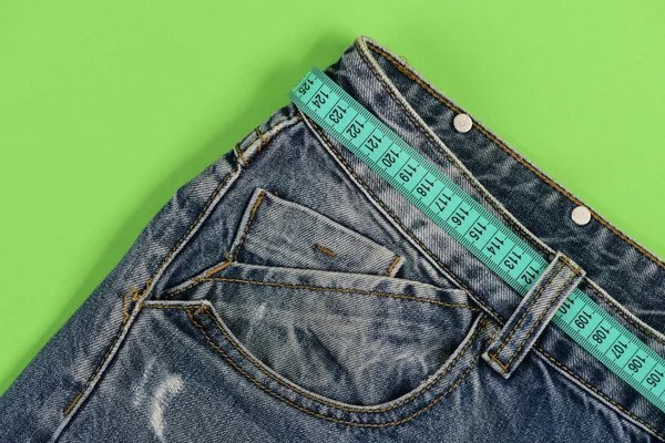 Sağlıklı yaşam tarzı ve diyet kavramı: kot mavi ölçü bandı ile — Stok fotoğraf