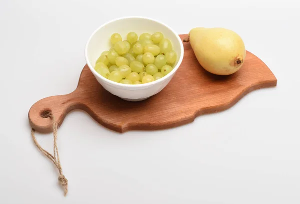 Placa de corte em forma de folha com frutas isoladas em backgroun branco — Fotografia de Stock