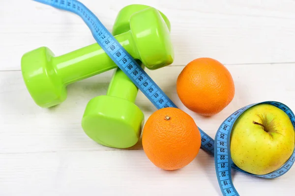 Workout concept, dumbbells weight with measuring tape, fruit — Stock Photo, Image